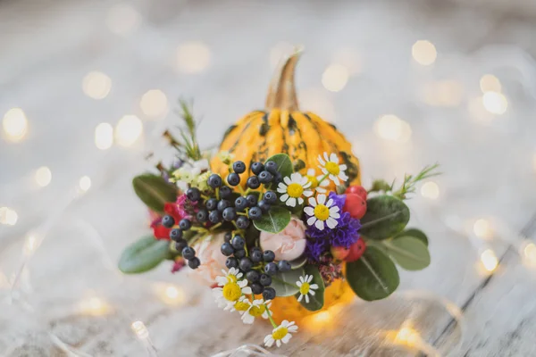 Halloween ou Thanksgiving fond. Composition d'automne en citrouille avec des fleurs sur fond en bois avec des lumières . — Photo