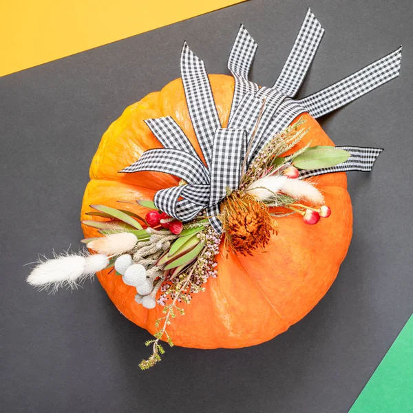 Halloween ou Thanksgiving fond. Composition d'automne en citrouille avec rubans et fleurs séchées sur fond sombre avec espace de copie . — Photo