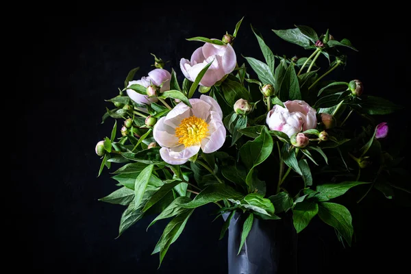 Bouquet de pivoines roses dans un vase gris sur fond sombre. Images De Stock Libres De Droits