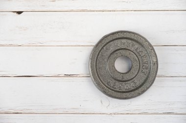 Beyaz boyalı ahşap arka planda metal bir plaka.