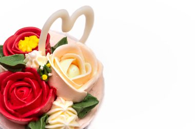 Beyaz arka planda izole edilmiş, güzel kremalı güllerle süslenmiş kek..