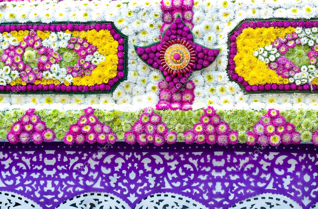 Closeup details of intricate patterns of flowers, seeds and papercut art on floats used in the February Flower Festival Parades in the City of Chiangmai, Thailand. The beautiful central mandala is made of red and green beans, corns, and rice.  