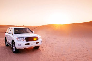 Dubai, Abu Dabi 'de çölde Sunset Safari' de. Al Wathba tatlısında gün batımına karşı SUV arabası
