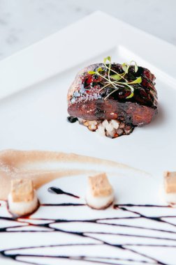 Tatlı ve ekşi balzamik soslu kızarmış kaz ciğeri, armut sosu ve kurabiye.