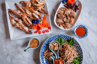 Phuket yerel yemek, bol yağda kızartılmış domuz göbeği, karides ezmeli ve otlu papaya salatası baharatlı soslu ızgara karides.