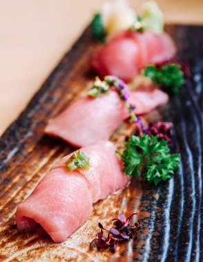 Japon Otoro Ton Balığı 'nın taze taze suşisi seramik tabakta, yakın çekim.