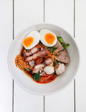 Domuz etli erişte, haşlanmış yumurta, ciğer, balık köftesi, beyaz kasede kırmızı baharatlı domuz eti. Üst görüntü görüntüsü