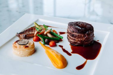 Beyaz tabakta fileminyon biftek ve güzel yemek stili süsleme.