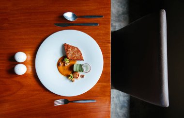 Deniz kabuğu ve scallop bifteği modern mutfak, ızgara deniz kabuğu ve ahşap masada beyaz tabakta krema soslu scallop.