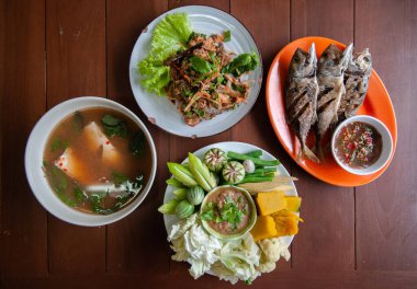 Nam Prik Pla To, kızarmış balık, baharatlı balık salatası, Tom Yum çorbası - Tayland sokak yemekleri seti ve taze sebzeler, balkabağı, salatalık, fasulye ve karnabahar