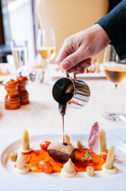 Kızarmış ördek göğsüne tatlı ve ekşi balzamik sos dökülüyor.