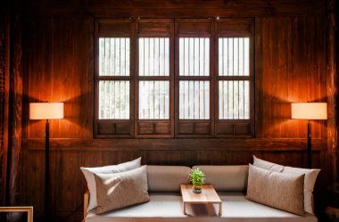 18 AUG, Hangzhou, Çin: Eski Çin ahşap evinde modern Çin tarzı oturma odası dekorasyonu, sıcak ışık, bej renkli kanepe ve lamba