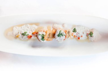 Beyaz bir tabakta ızgara, köpüklü sos, yakın çekim.