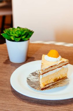 Asya stili kabarık mangolu pasta kremalı, beyaz tabakta taze mango.