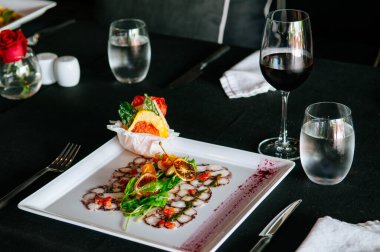 Turunçgil salatası soslu taze ahtapot carpacio, güzel yemek masası.