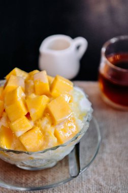Tatlı mango Binsu Kore tıraşlı buzlu tatlı cam kasede siyah çay, yakın çekim