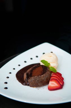 Erimiş çikolatalı lav keki, çilekli ya da beyaz tabakta fondant.