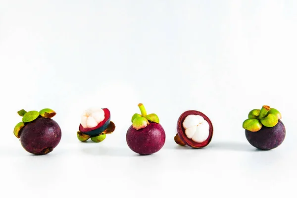 Isolated whole cut open mangosteens on white background.