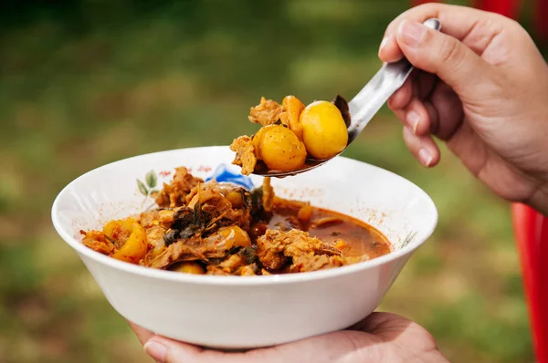 地元のエキゾチックな鶏未熟卵ホットカレーの女性のボウルを保持 スプーンで卵のスパイシーなカレーのタイのクラスタです 撃たれた — ストック写真