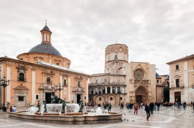 30 Ekim 2012 Valencia, İspanya - Fuente del Turia şelalesi ve Valencia Katedrali meydanında kilise ve çan kulesi olan turistler. Eski şehrin en ünlü eğlencesi.