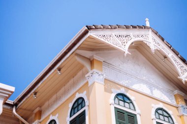 MAR 7, 2014 Bangkok, Tayland - Viktorya dönemi tarzı beyaz ahşap kaplamalı, açık sarı duvarlı, mavi gökyüzüne karşı Koloni mimarisi