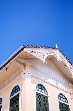 MAR 7, 2014 Bangkok, Tayland - Viktorya dönemi tarzı beyaz ahşap kaplamalı, açık sarı duvarlı, mavi gökyüzüne karşı Koloni mimarisi