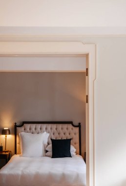 7 MAR 2014 Bangkok, THAILAND - Klasik ahşap yataklı, lambalı ve yastıklı koloni tipi beyaz yatak odası. Asya klasik ev dekorasyonu