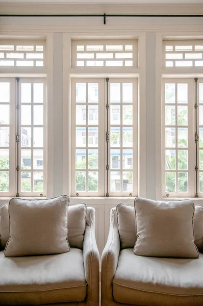 White colonial vintage living room with armchairs and classic minimal design pillow, cozy room with natural light through windows