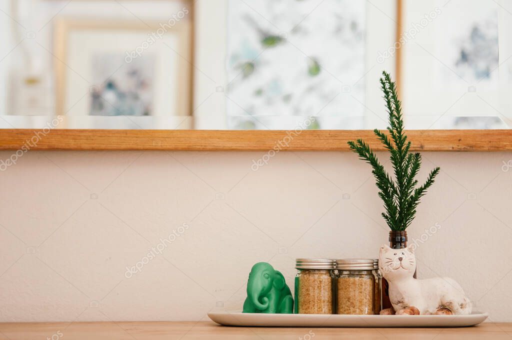 Cute craft caremic cat and elephant figures with pine leaf and brawn sugar bottles on wood counter in coffee cafe, coffee interior