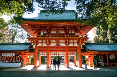DEC 10, 2012 Omiya, Saitama, JAPAN - Beautiful red entrance gate of Hikawa jinja shrine with beautiful sunlight in autumn clipart