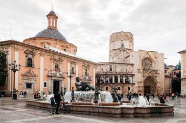 30 Ekim 2012 Valencia, İspanya - Fuente del Turia şelalesi ve Valencia Katedrali meydanında kilise ve çan kulesi olan turistler. Eski şehrin en ünlü eğlencesi.