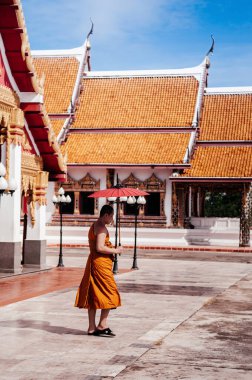 SEP 16, 2012 Sakon Nakhon, Tayland - Şemsiyeli Budist keşiş Wat phra 'da yürüyor Choeng chum, kutsal Sakon Nakhon Tapınağı - Tayland