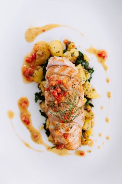 Izgara tavuk göğsü fırında patates ve limon yağı soslu lahana. Kırmızı biber ve dereotu beyaz tabakta servis ediliyor.