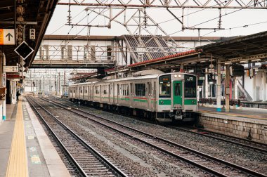 DEC 4, 2018 Koriyama, JAPAN - JR Koriyama istasyonunda sabah saatlerinde yüksek voltajlı metal elektrik kablosu ve boş bir platformla tren durağı