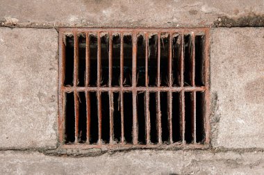 Paslı harabe metal kanalizasyon ızgarası şehrin üst manzarasında kirli demir drenaj kapağı