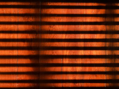 Yüksek kontrastlı ışık ve gölge şeritleri eski, kahverengi ahşap zeminde.