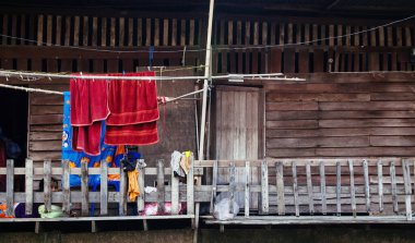 20 APR 2013 Bangkok, Tayland - Tayland eski ahşap evler Bangkok 'ta asılı renkli giysiler