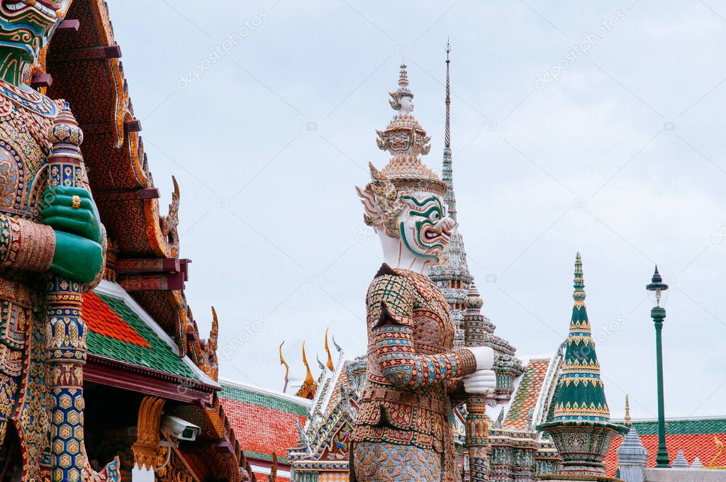 Beautiful elegant Artisan ceramic facade and giant statue of Bangkok Grand Palace building - Wat Phra Kaew - Emerald Buddha temple