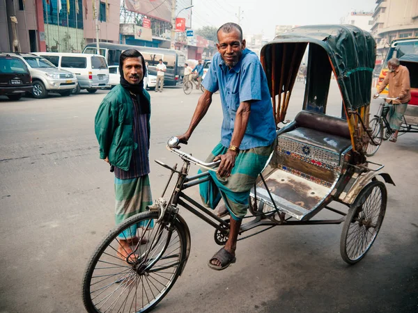 17 Şubat 2012 Dhaka, Bangladeş - Bangladeş halkı Dhaka City Dusty Caddesi 'nde trickshaw bisiklet sürücüleri. Güney Asya 'da işçi sınıfından insanlar