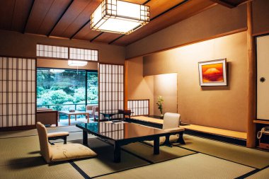 25 Mayıs 2013 Gifu, JAPAN - Sürgülü kapılı klasik Japon oturma odası, Tatami paspas, siyah ahşap masa ve retro tasarım koltukları. Tavan lambasından gelen sıcak ışık ve atmosfer