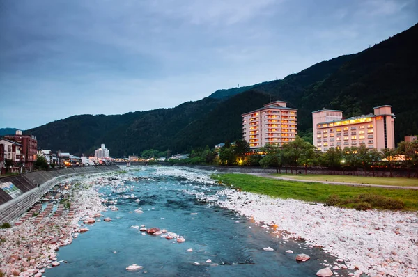 Japonya 'nın Gifu ilinde günbatımında Gero onsen tatil köyündeki doğal dere ve yeşil dağ vadisi.