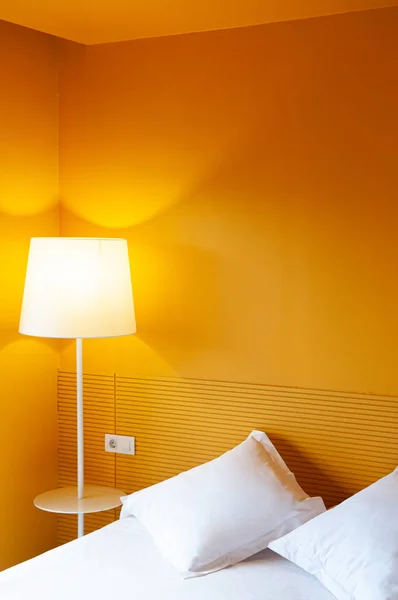 Bright Yellow wall  bedroom decoration with lamp, hotel style pillow and clean linen