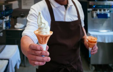 Taze buz gibi soğuk kremalı, zengin, Wasabi dondurma külahı Japon Wasabi dondurması bir erkeğin elinde.