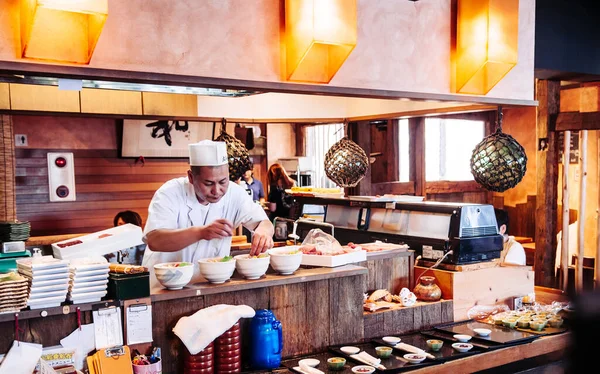 26 Haziran 2014 Kawasaki, Japonya: Japon şef yerel küçük Japon restoranında sashimi pilav kasesi hazırlıyor