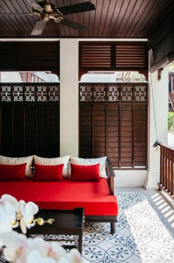 MAR 5, 2012 Chiang Mai, Tayland - Asya çağdaş verandasında kırmızı koltuk ve dinlenme alanı ön planda White Phalaenopsis orkidesi