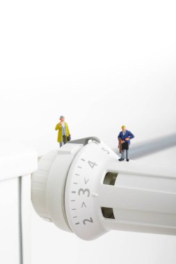 Radyatör ve küçük figürler. İki iş adamları ve Isıtma pil. Isıtma sezon kavramı