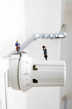 Radyatör ve küçük figürler. İşadamı ve tüketici ve Isıtma pil.