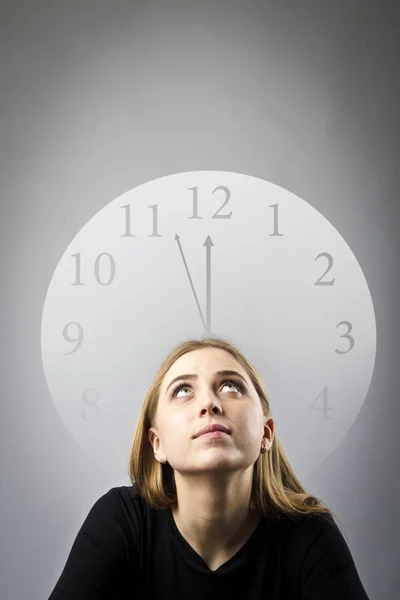 Jeune femme en noir et horloge — Photo