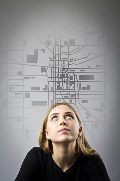 Mujer joven de negro está buscando una ruta en el mapa de la ciudad . — Foto de Stock