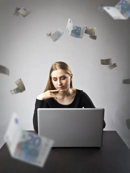 Jonge vrouw met laptop. Jonge vrouw en de dalende waarde van de eurobankbiljetten. — Stockfoto